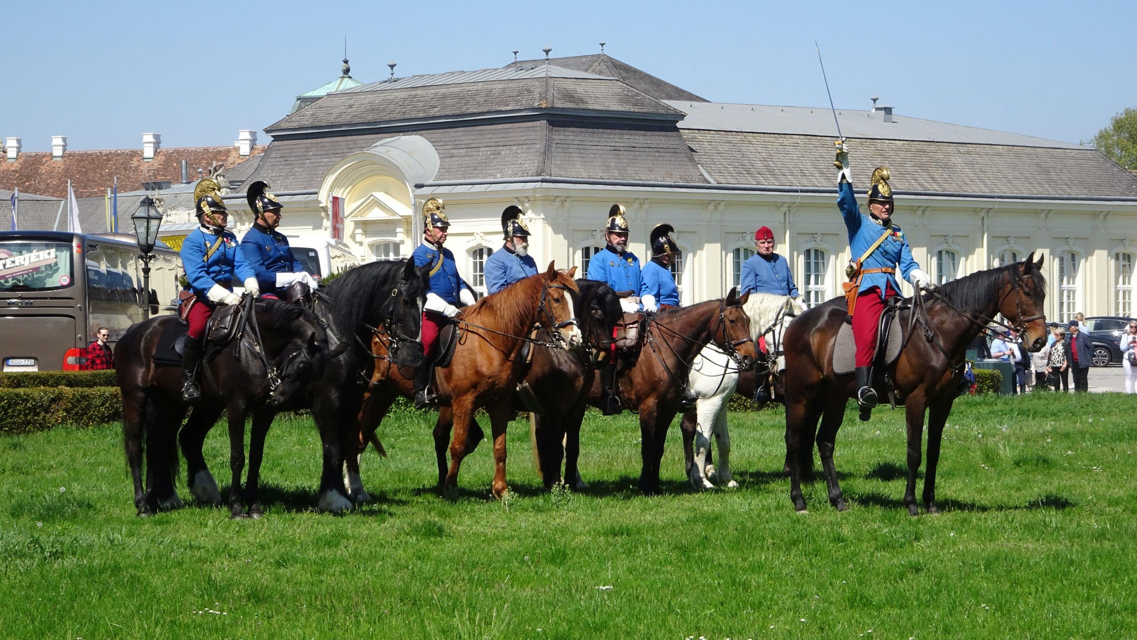 Foto von Soldaten in traditionellem Gewand die auf Pferden reiten.