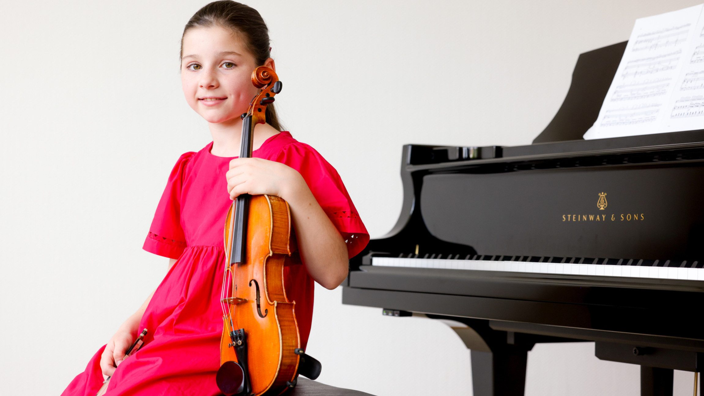 Blick auf die Violonistin Eloisa Aubert, die mit ihrer Violine vor einem Klavier sitzt.
