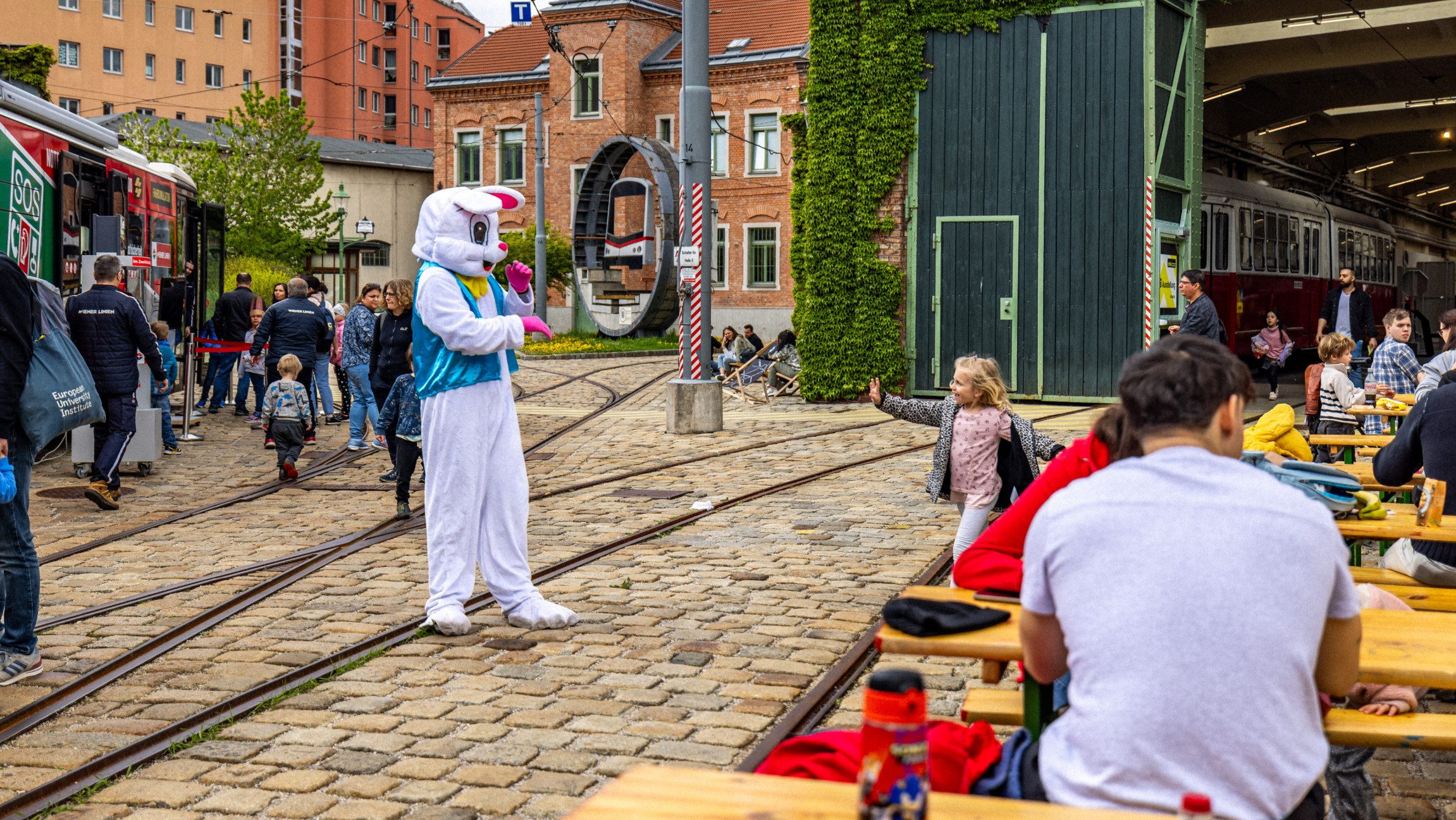 Blick auf Heurigentische und ein Person im Osterhasenkostüm.