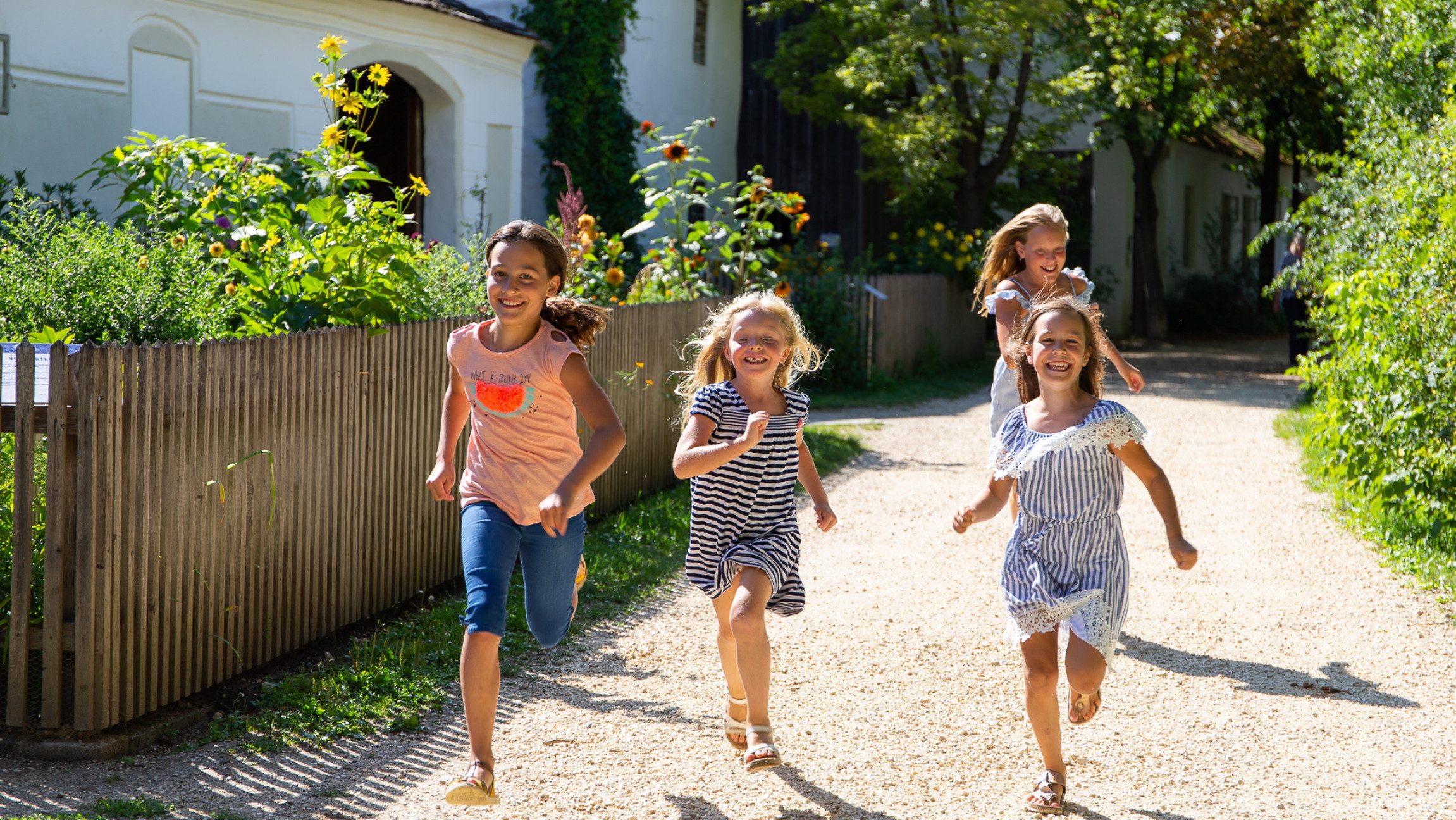 Kinder laufen auf einem Schotterweg.