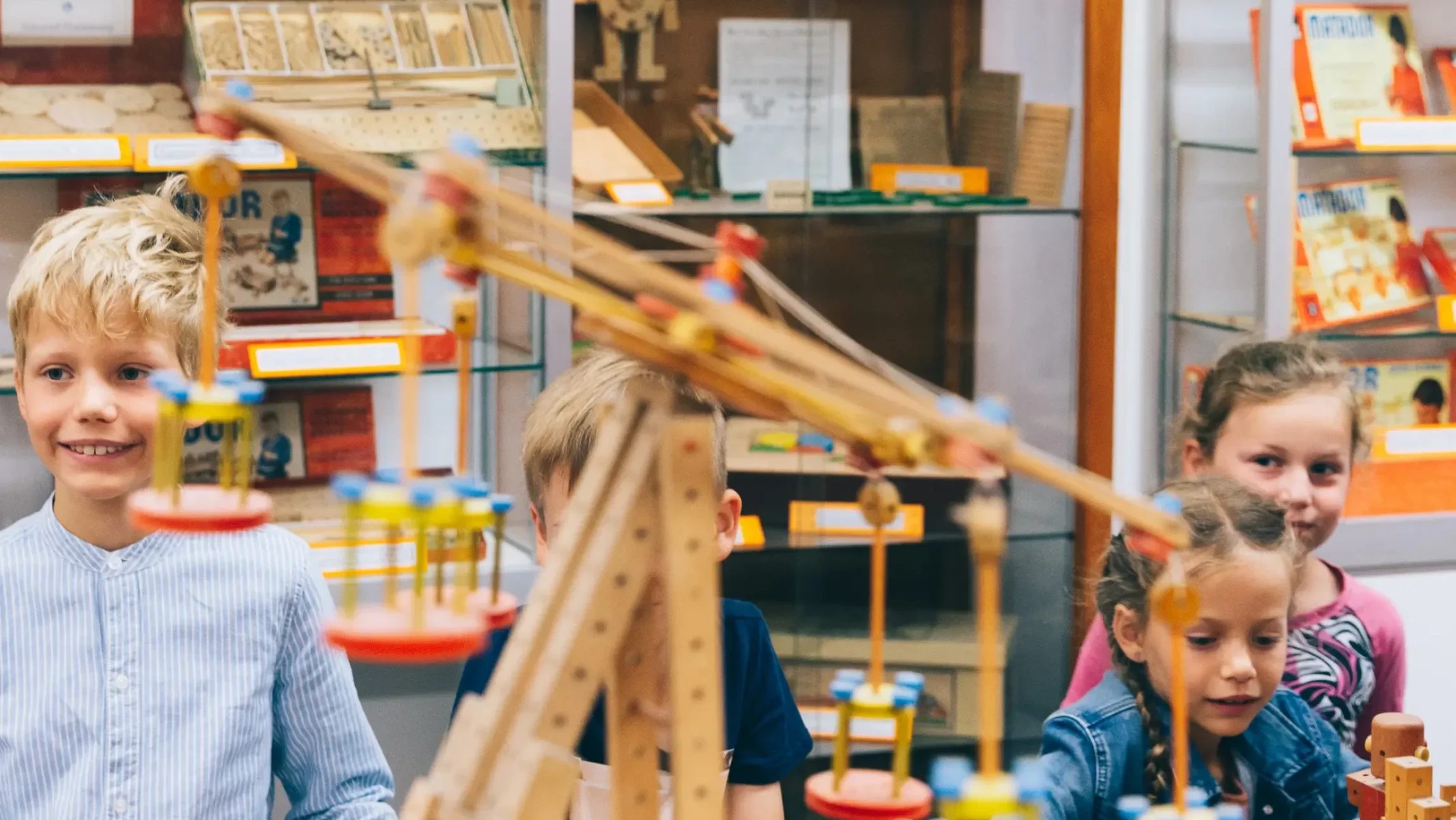 Kinder mit Matador-Bauwerken aus Holz.