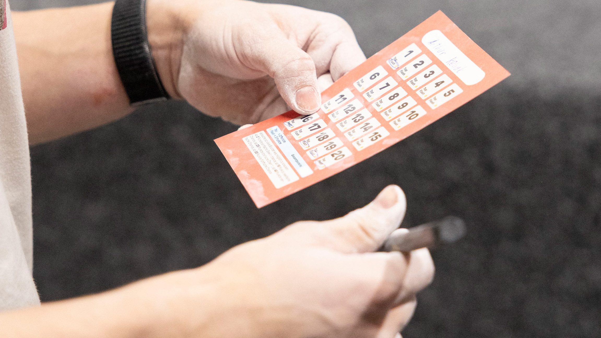 Foto von einer Person, die eine Scorecard in den Händen hält.