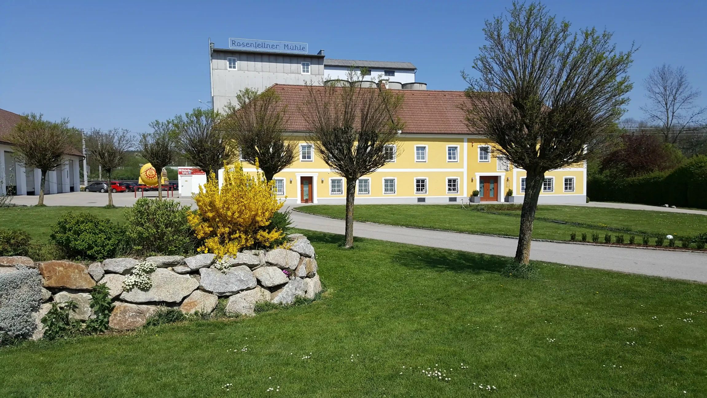 Blick auf das Gebäude und eine Wiese bei der Rosenfellner Mühle.