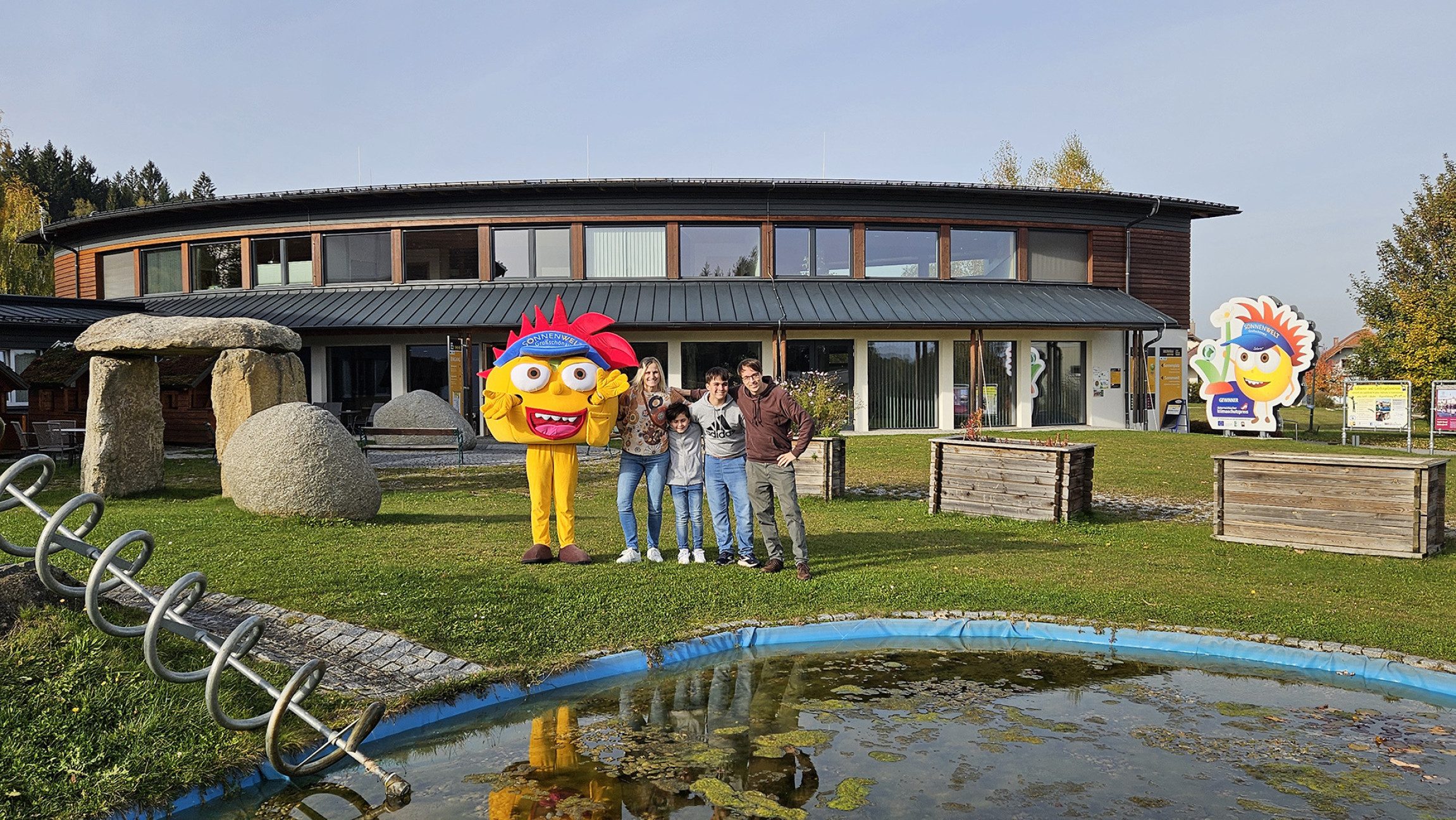 Blick auf das Sonnenwelt-Maskottchen, das vor der Sonnenwelt steht.