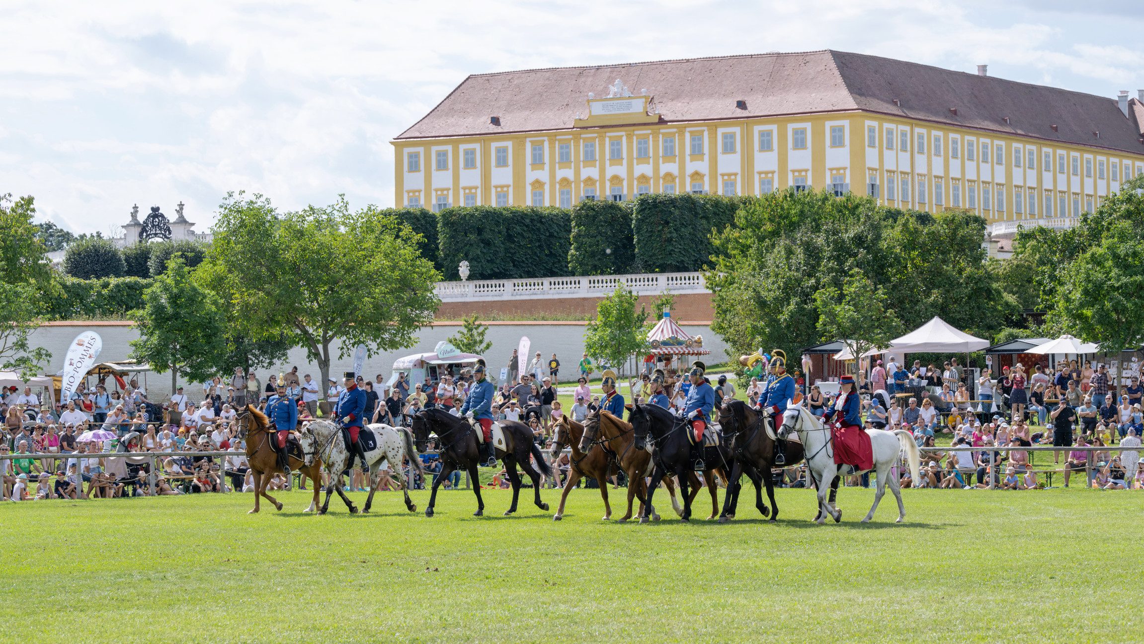 Foto von einem Pferdeaufmarsch mit vielen Zusehern bei Schloss Hof.