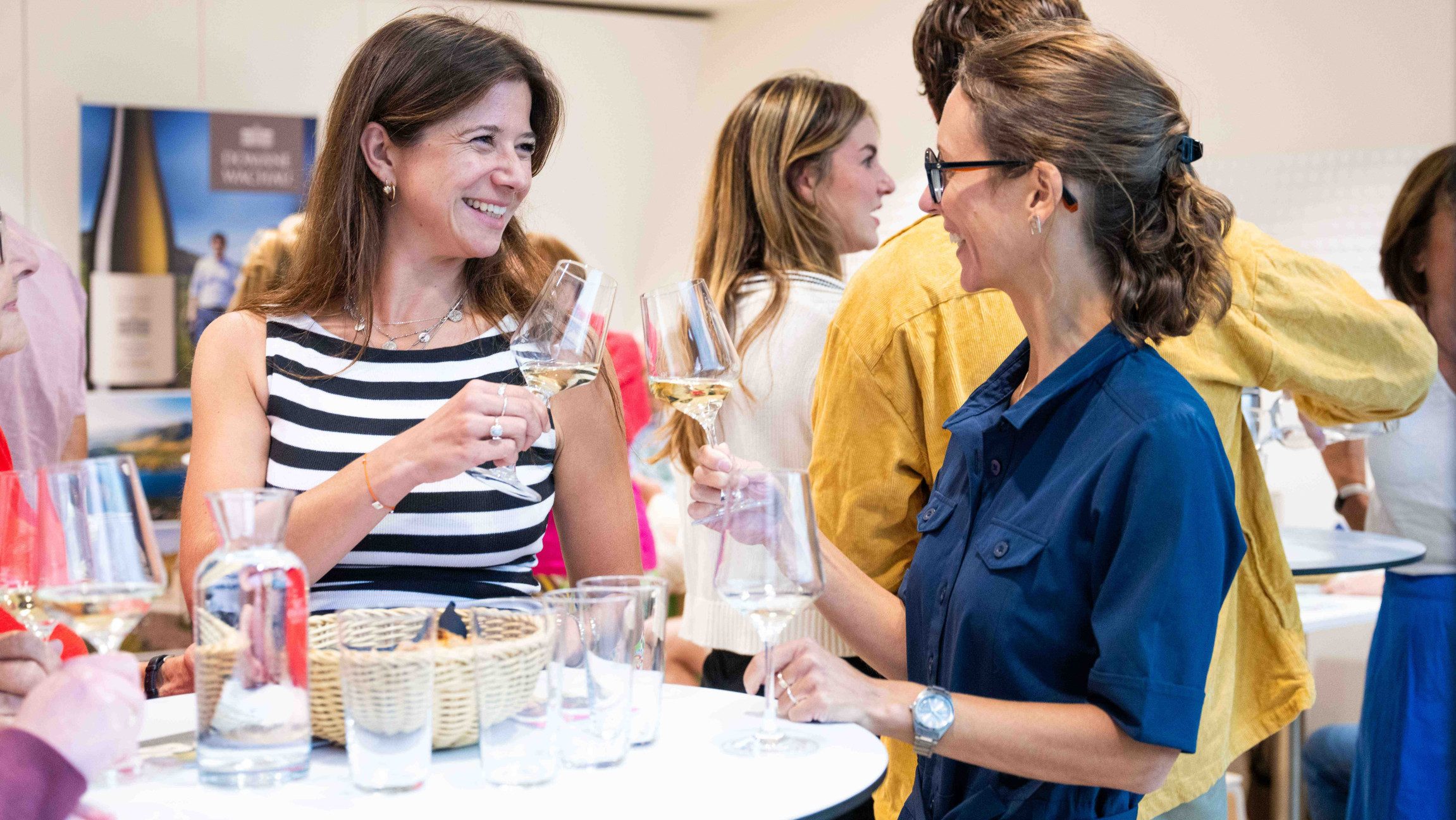 Gäste am Stehtisch mit einem Achterl Wein in der Landesgalerie Niederösterreich.
