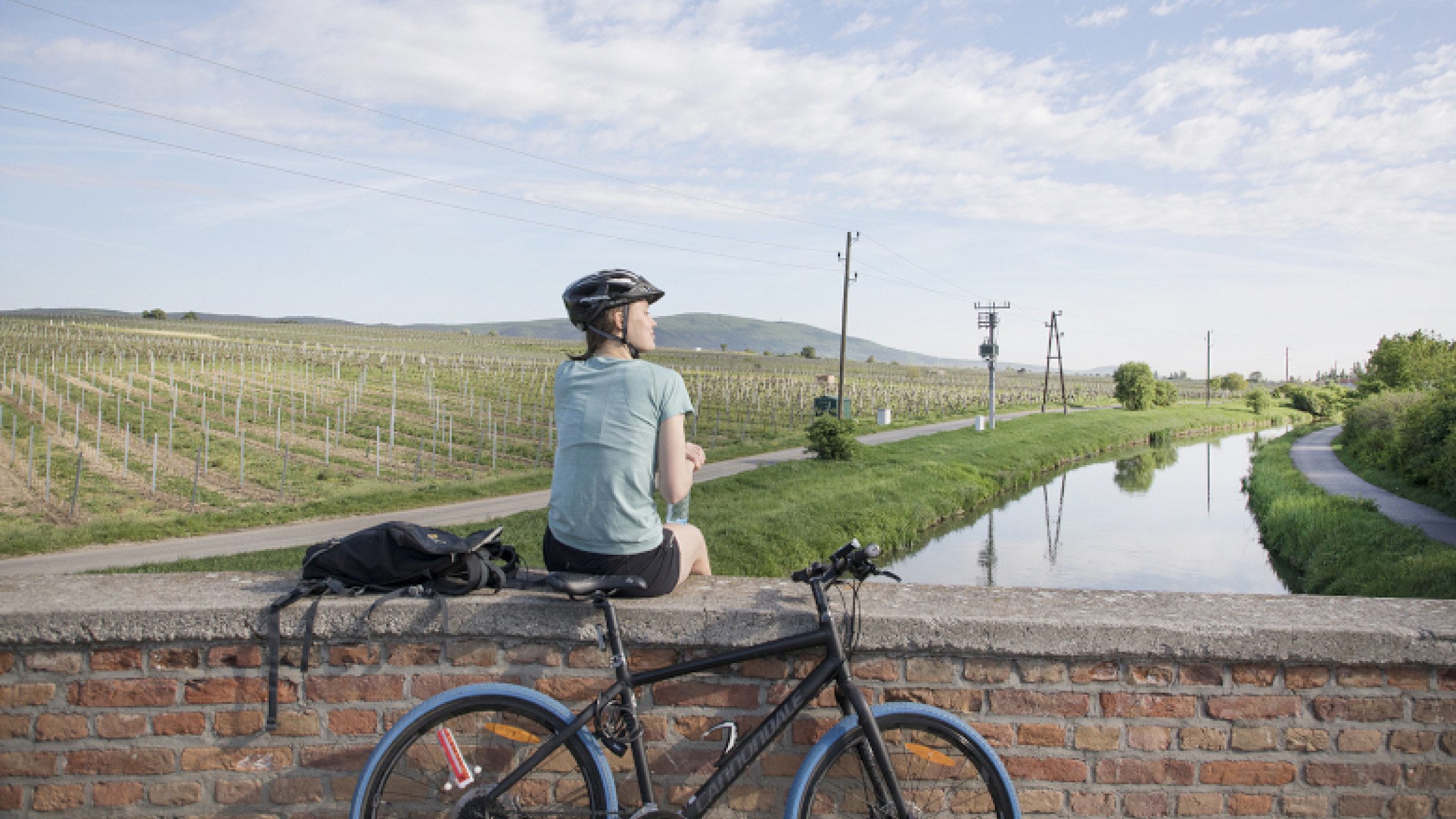 Eine Radfahrerin, die im WienerWald entlang des Thermenradwegs Pause macht