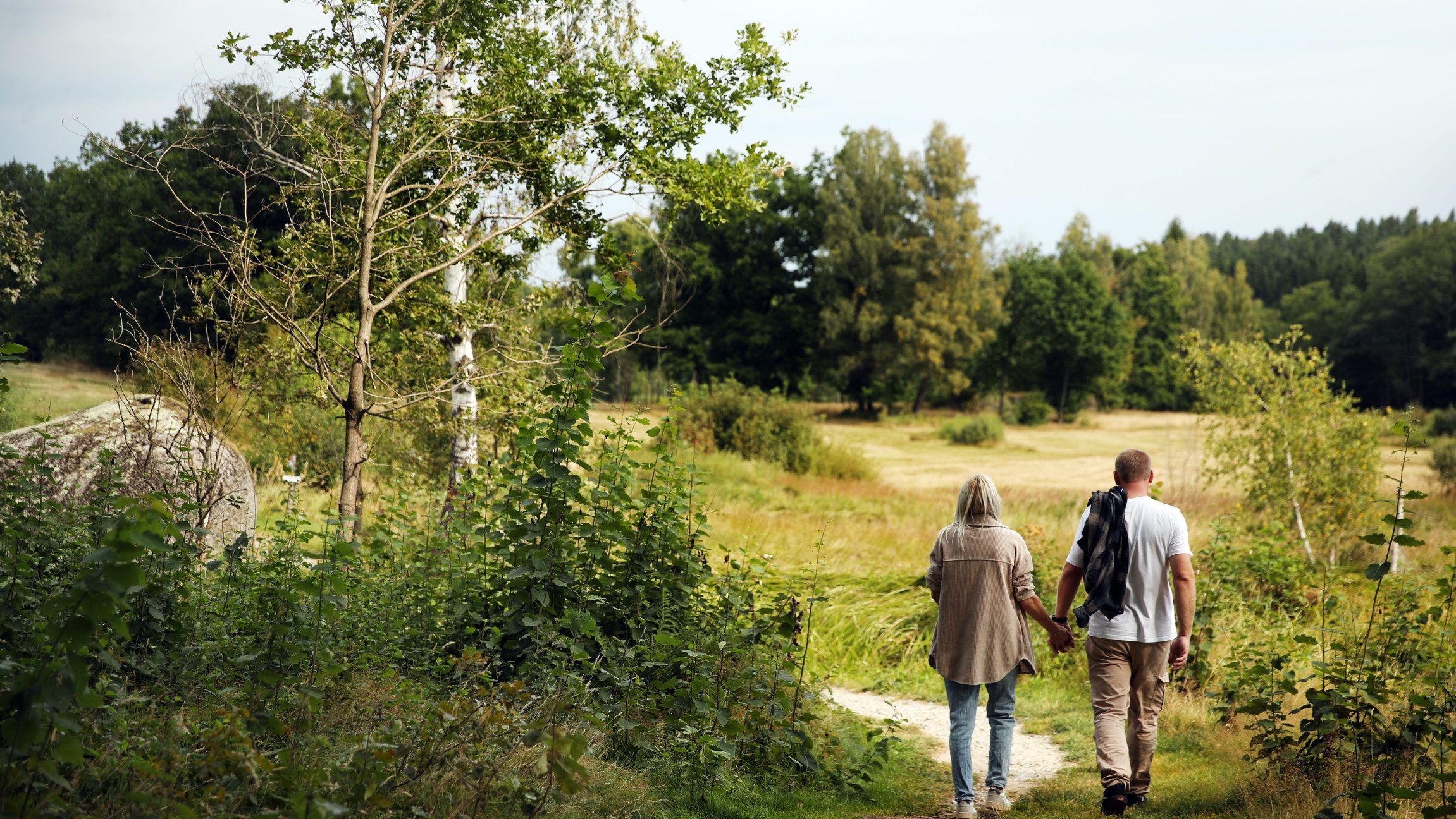 Ein Pärchen spaziert durch die saftig grüne Natur des Naturparks Blockheide