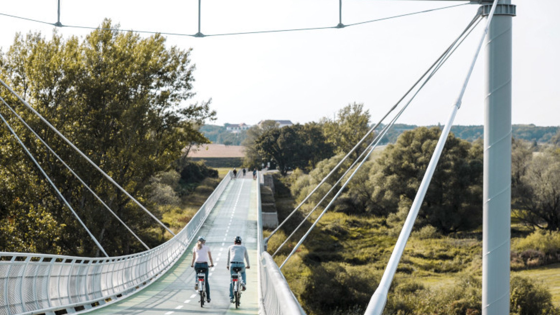Zwei Radfahrer:innen am Donauradweg im Frühling