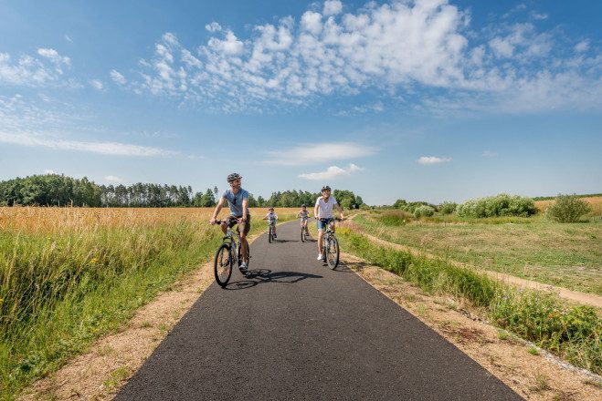 Eine Familie beim Radfahren an der Thayarunde zwischen Feldern