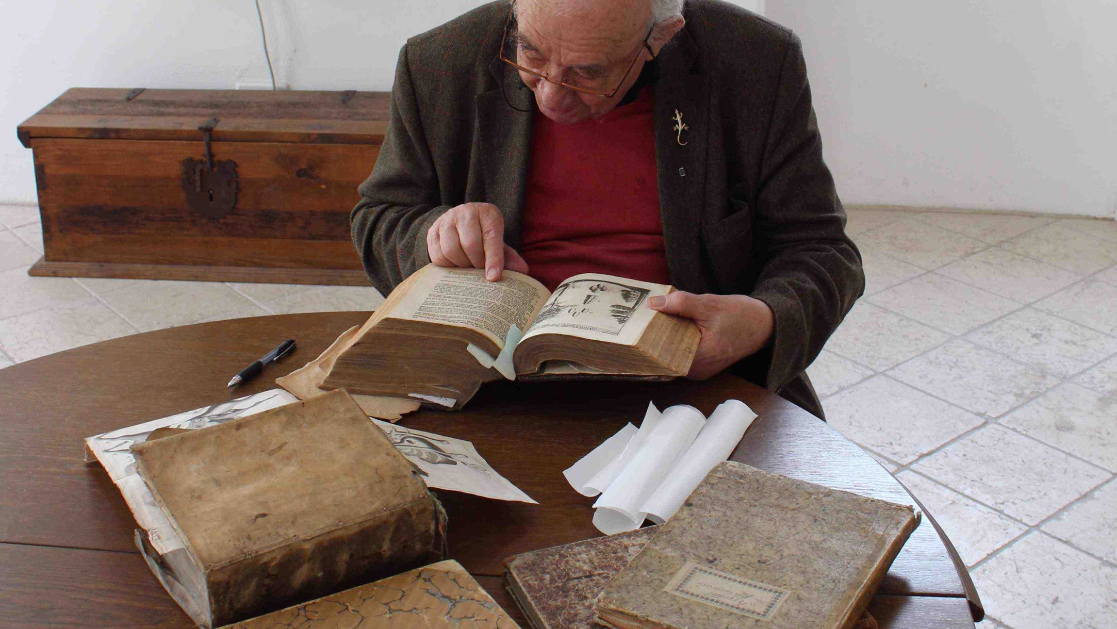 Daniel Spoerri mit Büchern aus seiner Kochbuchsammlung