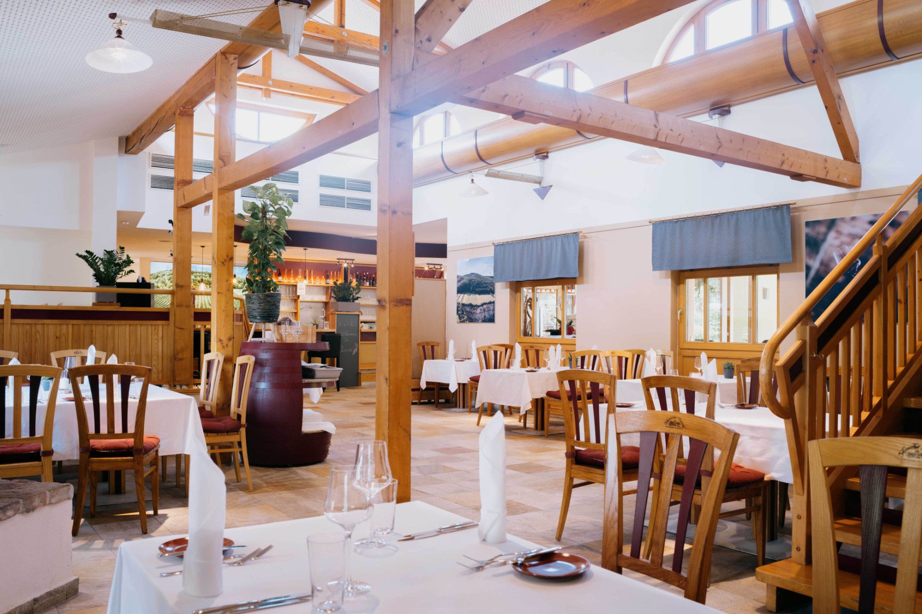 Gaststube mit Atmosphäre stiftenden Holzelementen und Weingartenblick
