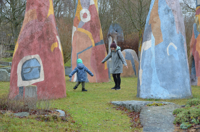 Frau und Kind zwischen bemalten Felsen in der Natur