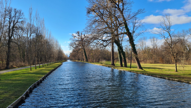 Bach der durch den Schlosspark fließt Umgeben von Wiesen und Bäumen