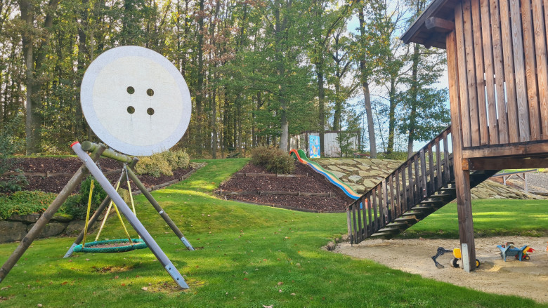 Blick auf Spielplatz, Wald im Hintergrund