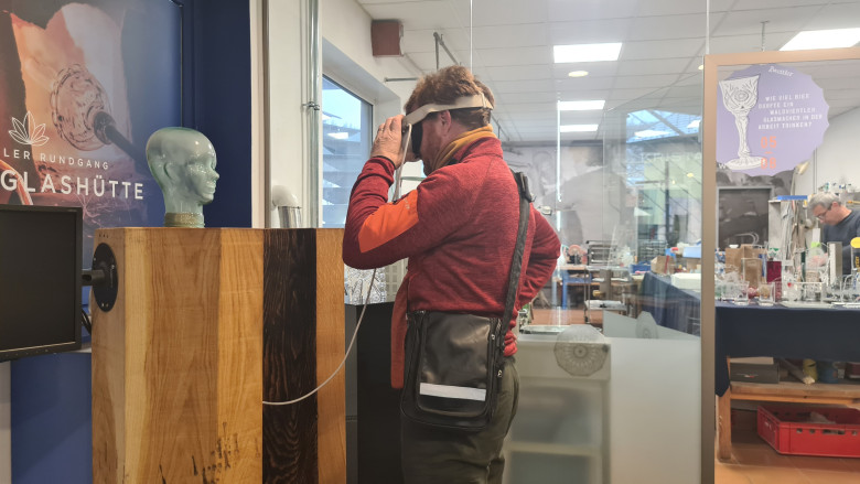 Mann mit VR-Brille schaut sich eine Skulptur an
