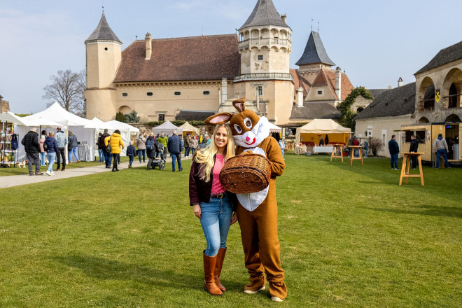 Ein Mensch im Osterhasen-Kostüm gemeinsam mit einer normal gekleideten Dame im Innenhof der Rosenburg