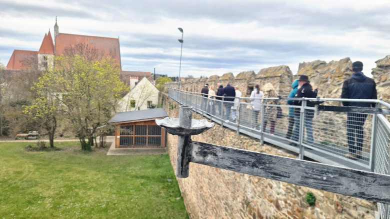 Menschen die auf einem Gittersteg entlang der Stadtmauer in Eggenburg gehen