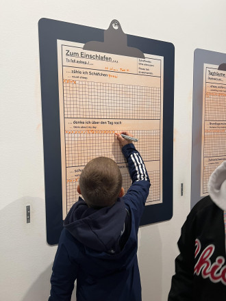 Ein Junge der auf einer Liste einträgt was er macht um Einschlafen zu können