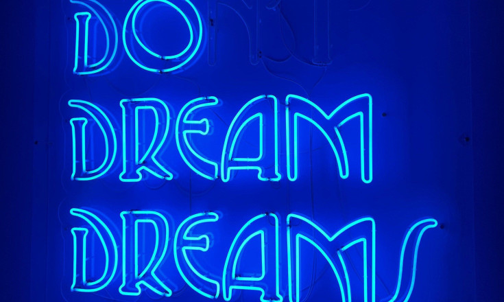 Ein LED Schriftzug in blau mit den Worten "Do Dream Dreams"