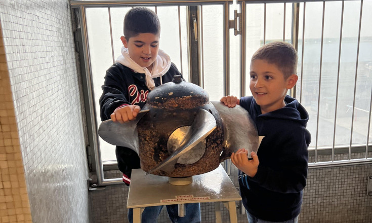 Zwei Jungs die an einer Kurbel drehen