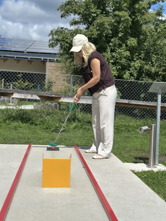 Blick auf eine Frau beim Minigolf