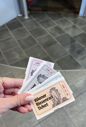 Person hält Tickets zur Riesenrad Fahrt