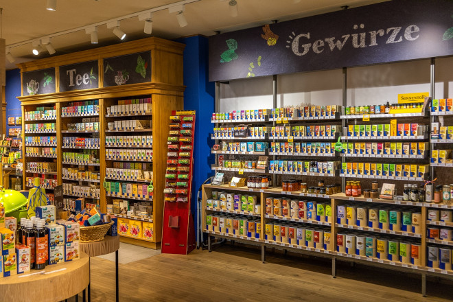 Blick in den SONNENTOR Shop mit einer großen Auswahl an Tees, Gewürzen und Bio-Produkten. Die Regale sind mit bunten Verpackungen und regionalen Spezialitäten gefüllt.