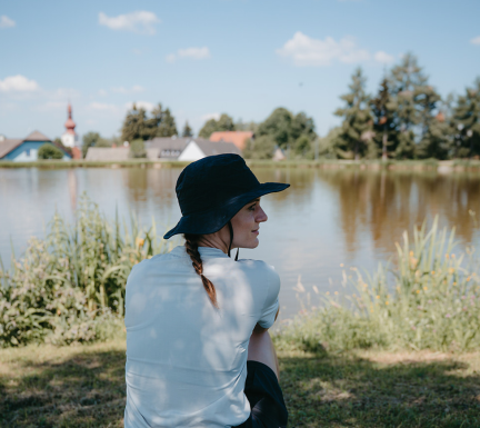 Eine Frau sitzt vor einem Teich in Ottenschlag