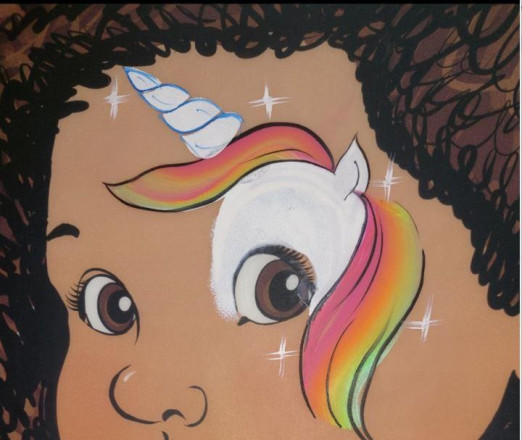 Gezeichnetes Bild eines Kindes, das um ein Auge ein Einhorn gezeichnet hat.
