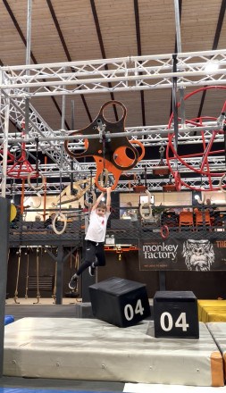Ein junger Bursche der sich an einem Kletterpark entlang handelt