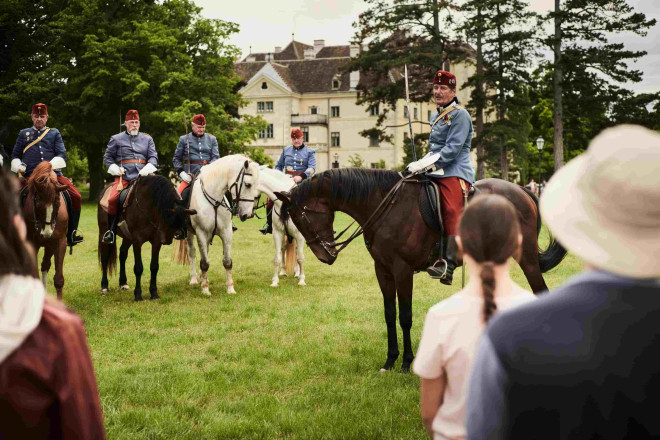Kaiserlich gekleidete Reiter mit ihren Pferden im Schlosspark Laxenburg.