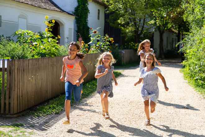 Kinder laufen auf einem Schotterweg.