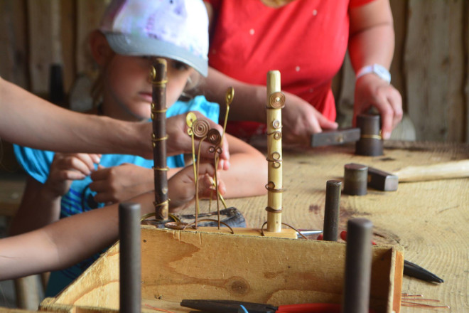 Kinder lernen im Keltendorf, wie Schmuck aus Metall hergestellt wurde und wie sich die Leute schmückten.