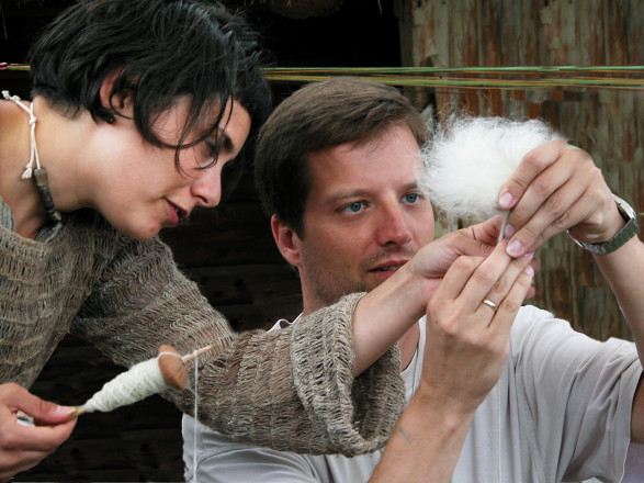 Foto von zwei Erwachsenen die Wolle spinnen.