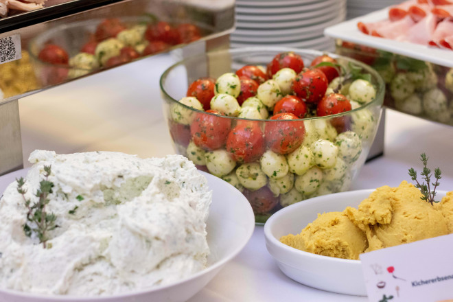 Blick auf zwei Aufstriche und eine Glasschüssel mit Cherry Tomaten und Mini-Mozarella.