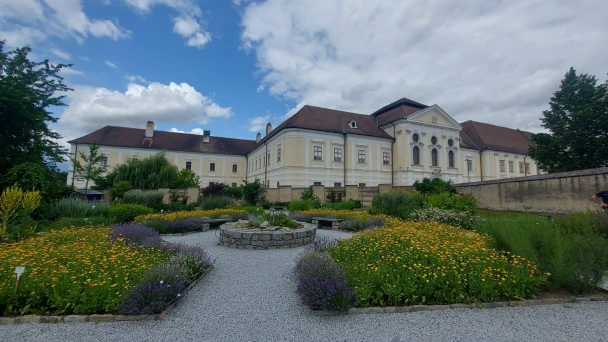Der blühende Garten mit dem gelben Gebäude im Hintergrund.