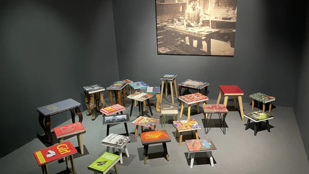 Blick auf einen Ausstellungsraum mit verschiedenen Büchern auf Hockern.