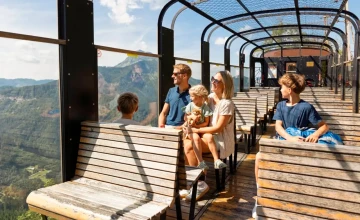 Blick auf eine Familie, die im Panoramawagon vom Ötscherbären fährt.