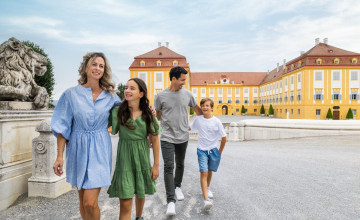 Blick auf eine Familie, die vor Schloss Hof spaziert.