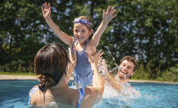 Eltern und Tochter planschen vergnügt im Außenbereich der Sole Felsen Welt.