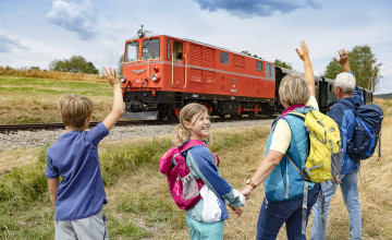 Blick auf die Waldviertelbahn der eine Familie zuwinkt.