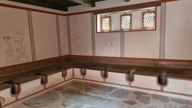Blick in den römischen Toilettenraum mit mehreren Sitzen.