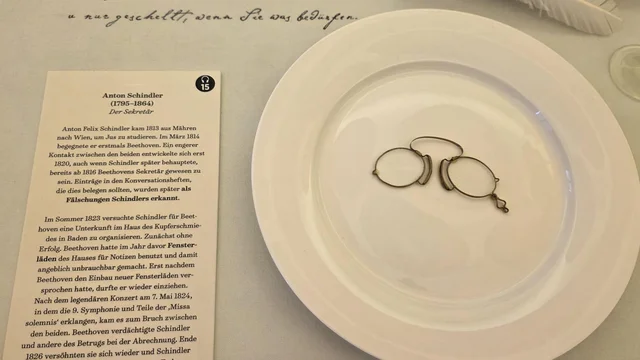 Blick auf ein Teller mit Brille und Schriftstück zu Anton Schindler