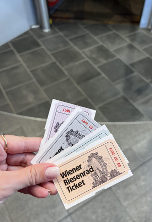Person hält Tickets zur Riesenrad Fahrt