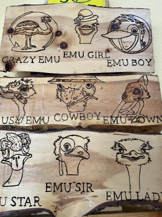 Ein Holzschild, in dem die Namen und Gesichter der Strauße graviert sind