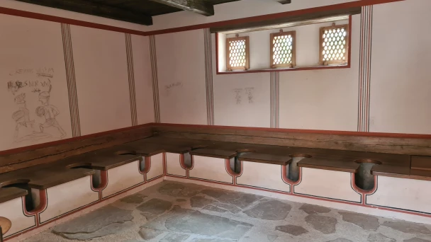 Blick in den römischen Toilettenraum mit mehreren Sitzen.