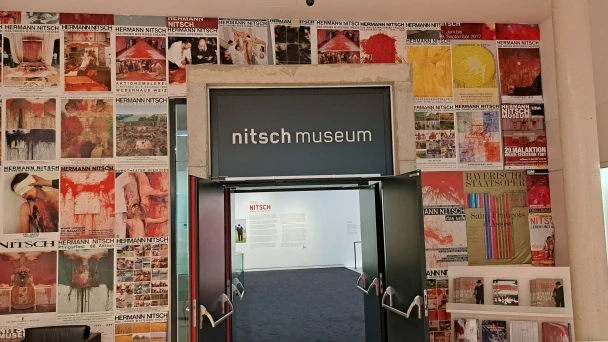 Blick auf den Eingang ins nitsch museum mit seinen Werken an der Wand.
